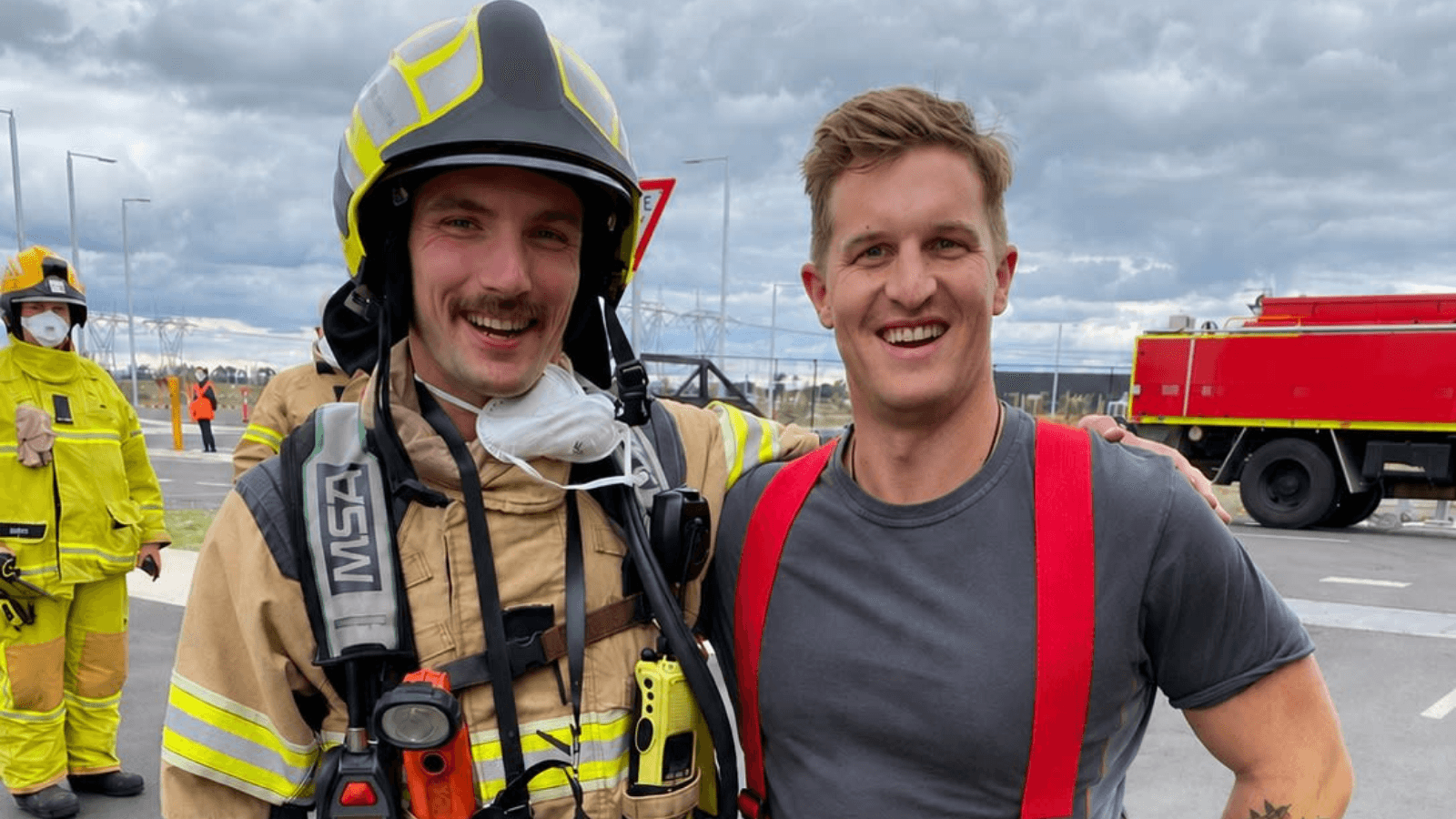 Rick from Code One Support with a fire fighter in breathing apparatus and fire truck in the background